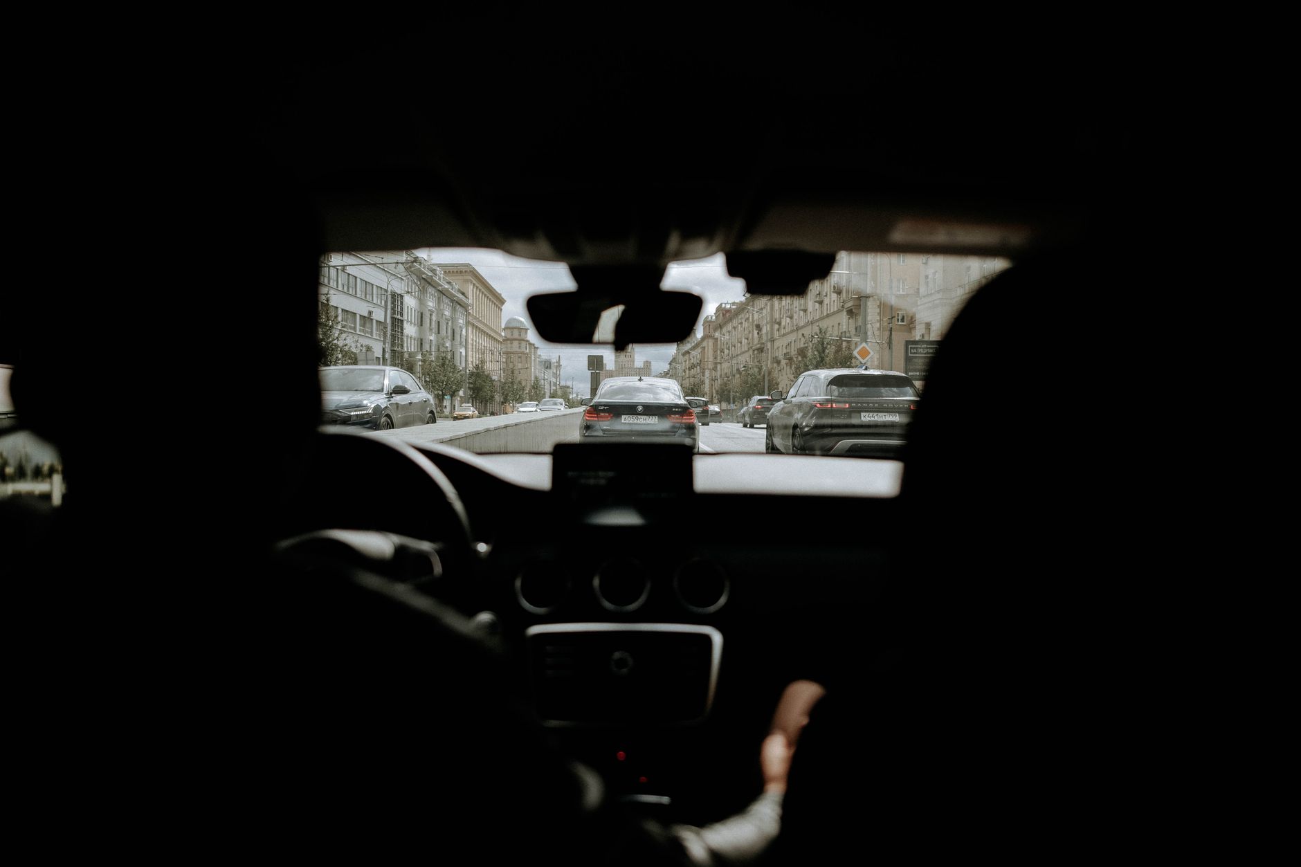 A cidade vista de dentro do carro, com o trânsito pela frente