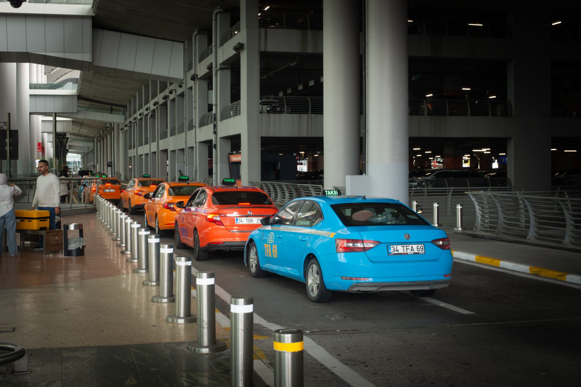Fila de táxis à espera à porta das chegadas do aeroporto